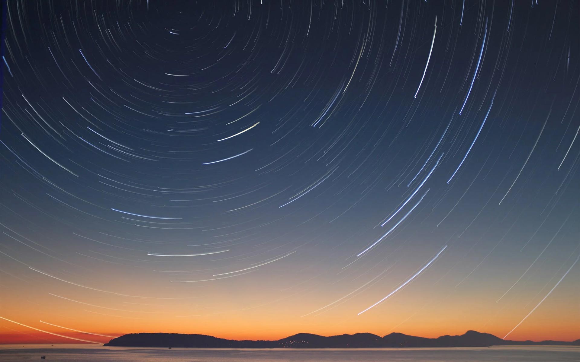Star trails imposed on a costal sunset